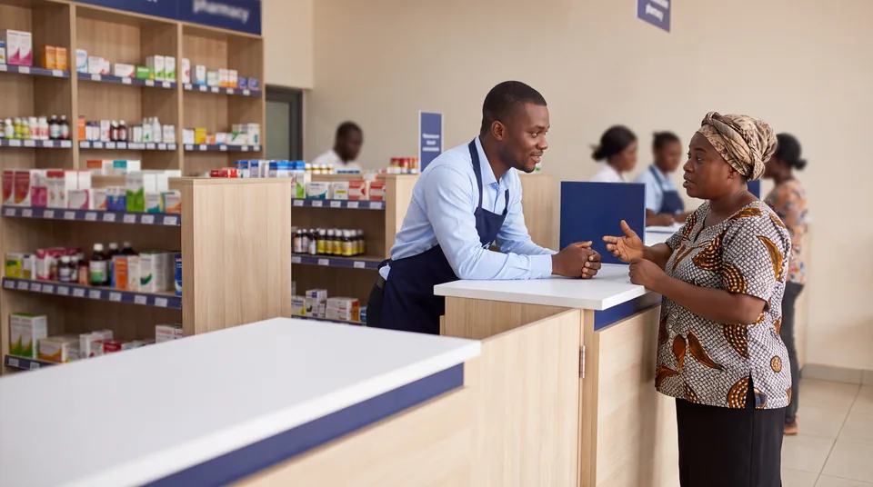 Pharmacy staff member helping a customer in Ghana